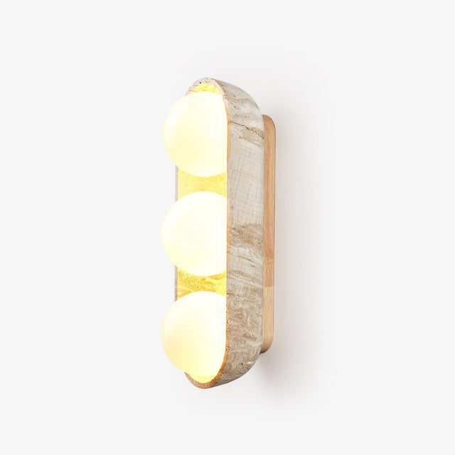 Three light wall sconce, three glass orbs held in a carved travertine shell