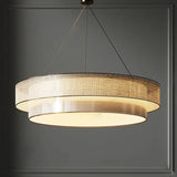 Tiered drum pendant light seen from below against a dark wall