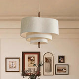 Two tier drum shade hung beside a wall of framed pictures