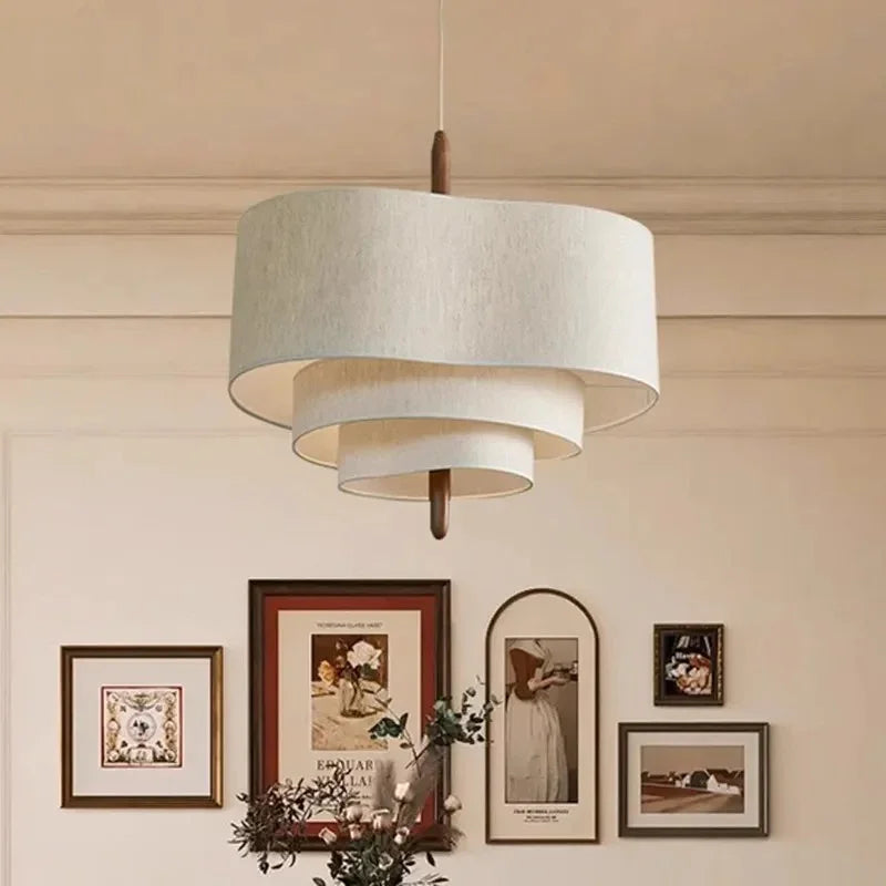 Two tier drum shade hung beside a wall of framed pictures