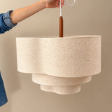 Two tier drum shade held up against a pale wall