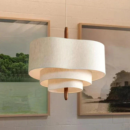 Two tier drum shade in a room with framed art and plants