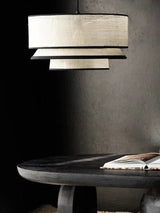 Tiered drum pendant light above a dark dining table