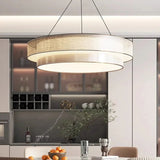 Tiered drum pendant light in beige fabric above a kitchen counter