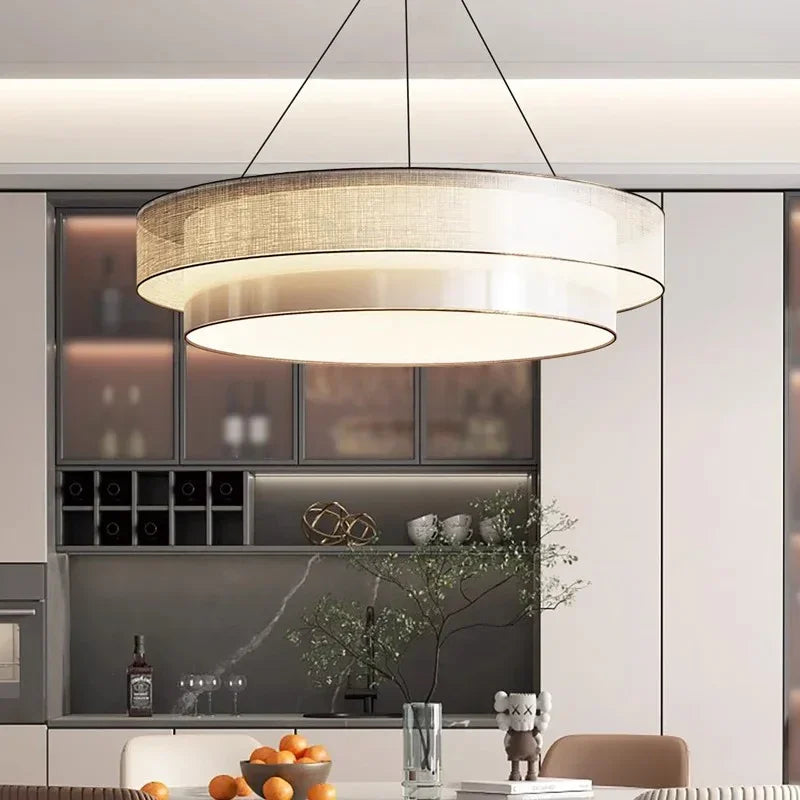 Tiered drum pendant light in beige fabric above a kitchen counter