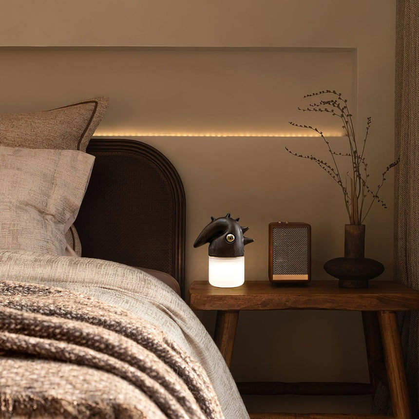 Touch control bedside lamp lit on a nightstand in a warm bedroom