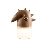 Natural wood touch control bedside lamp lit, seen at an angle