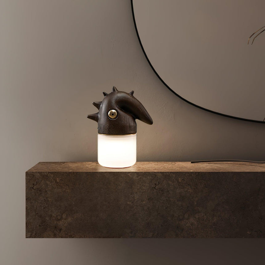 Touch control bedside lamp lit on a dark console below a mirror