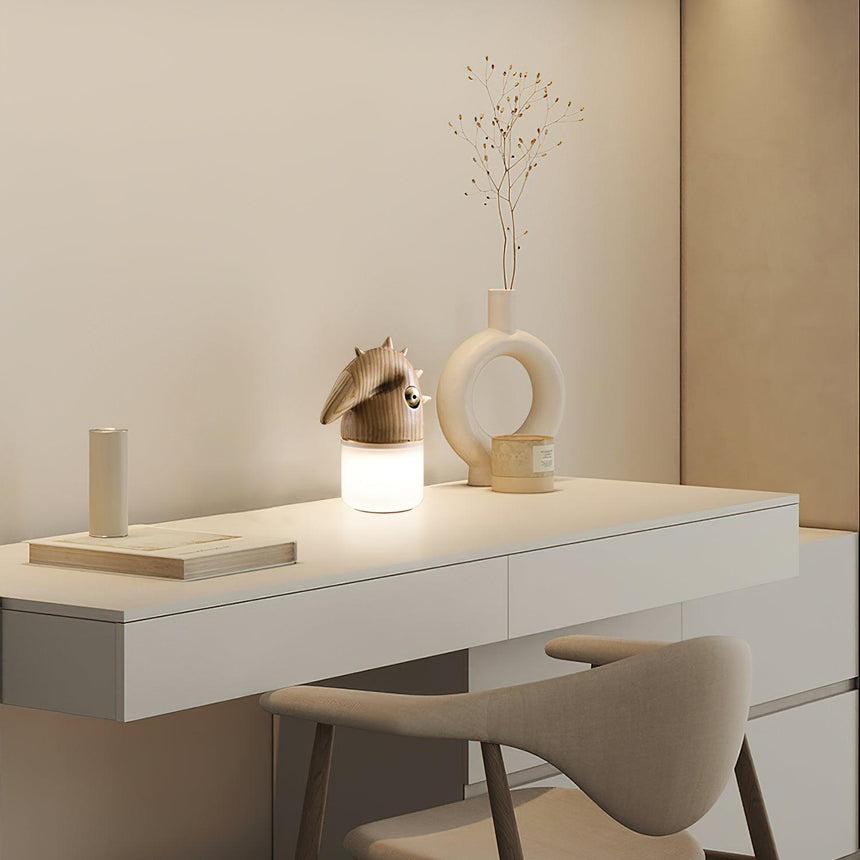 Touch control bedside lamp lit on a white desk beside a chair