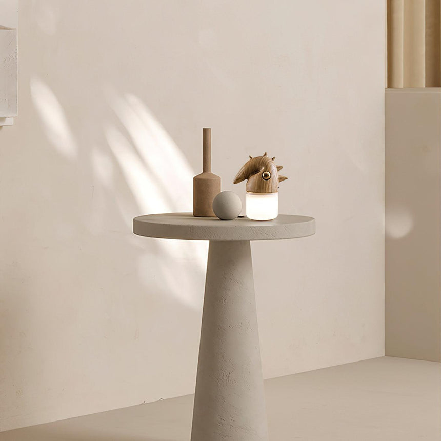 Touch control bedside lamp lit on a pale round table in sunlight