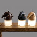 The three finishes of the touch control bedside lamp lit on a wood table