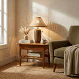 Traditional table lamp with a rattan shade lit on a side table