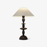Traditional table lamp with a turned spindle base and a wide linen shade