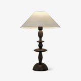 Turned spindle table lamp seen front on with the shade slightly above