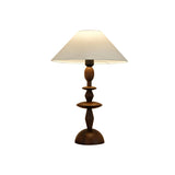 Turned spindle table lamp in a walnut tone against a plain white ground