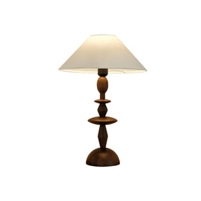 Turned spindle table lamp in a walnut tone against a plain white ground