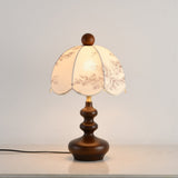 Front view of the toile shade lamp lit on a pale surface