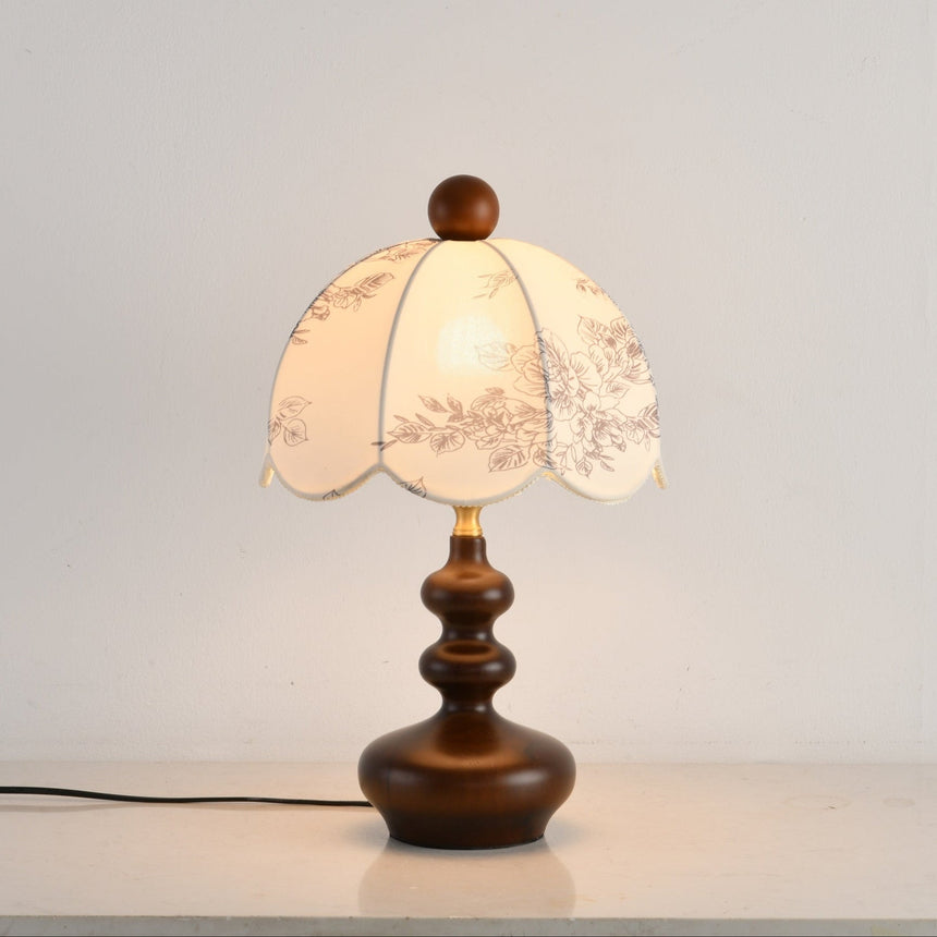 Front view of the toile shade lamp lit on a pale surface