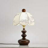 Scalloped toile shade lamp lit against a pale wall