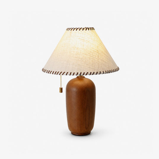 Traditional table lamp with a cream woven shade on a turned wood body