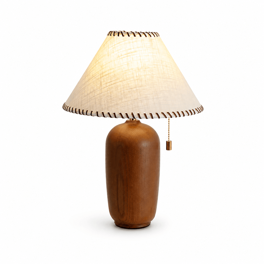 Traditional table lamp with a woven shade bound in leather, lit