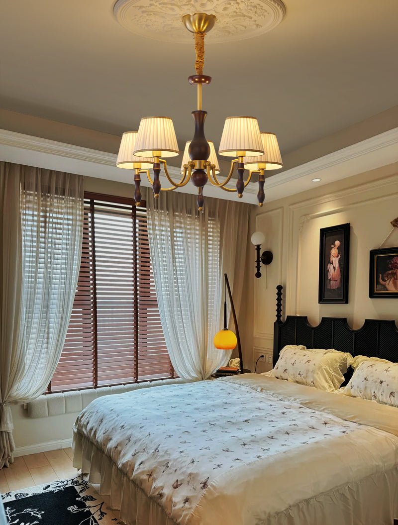 The fitting lit in a bedroom above a bed with a patterned cover