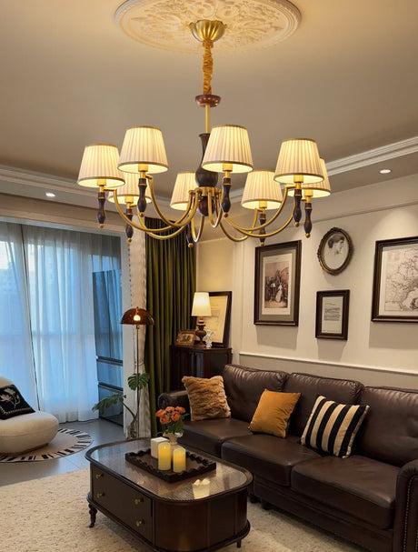 Chandelier lit in a living room with a blue curtain and a dark sofa