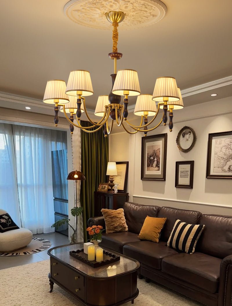 Chandelier lit in a living room with a blue curtain and a dark sofa