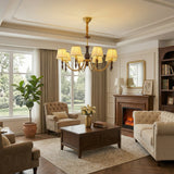 Chandelier lit in a living room above a sofa beside a fireplace