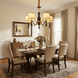 Chandelier lit above a long dining table with upholstered chairs