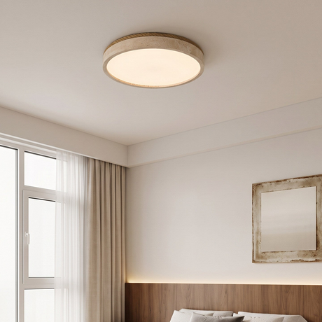 Round travertine ceiling light in a bedroom with a wood ledge and a framed artwork