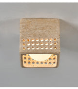 Underside of the square travertine block ceiling light with a lit diffuser