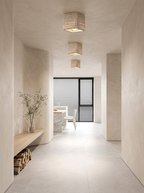 Square travertine block ceiling light in a plaster hallway leading to a dining area