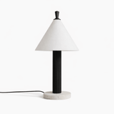 Travertine table lamp with a black fluted column seen from the front