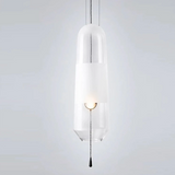 A clear glass tube pendant lit with its white inner cylinder showing