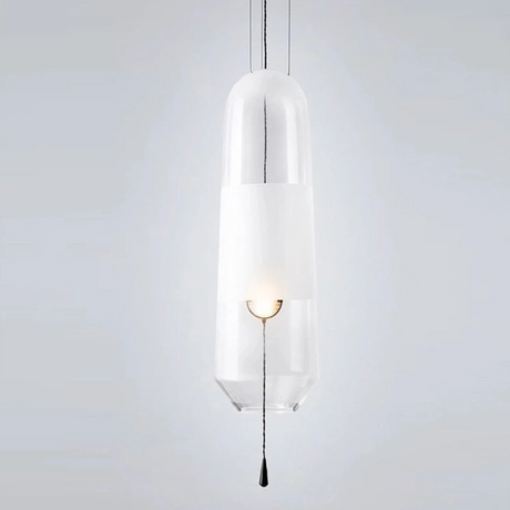 A clear glass tube pendant lit with its white inner cylinder showing