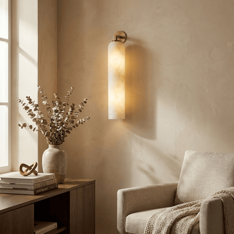 The lit tube beside an armchair above a table with a vase of stems