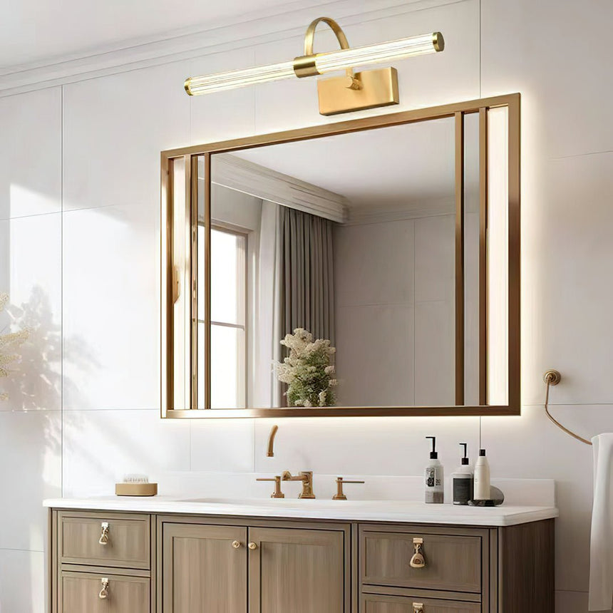 Brass arch and tube lit above a gilt framed mirror over a pale double vanity