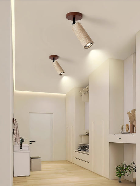 Travertine tube on a hallway ceiling washing light down a pale wall