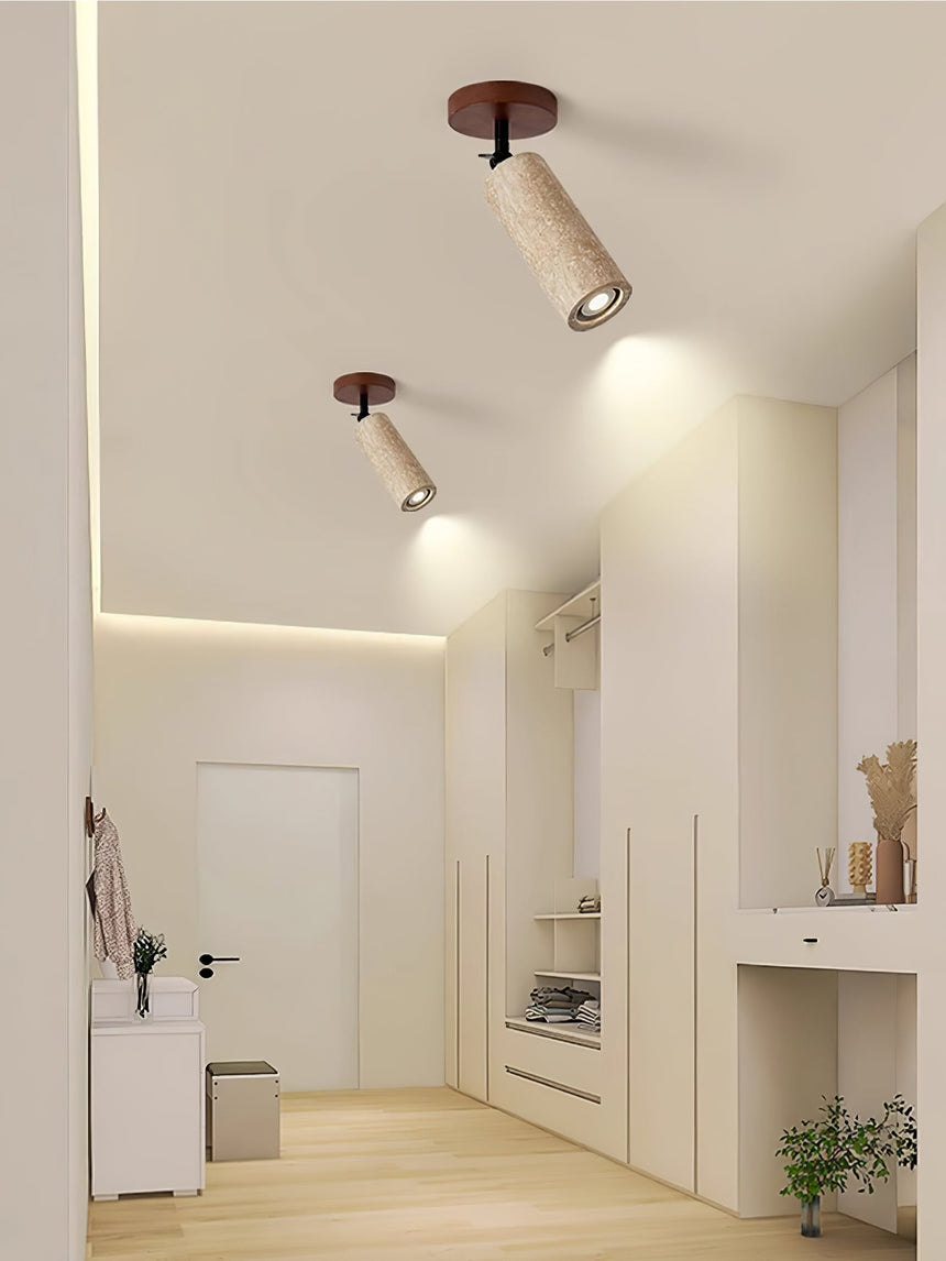 Travertine tube on a hallway ceiling washing light down a pale wall