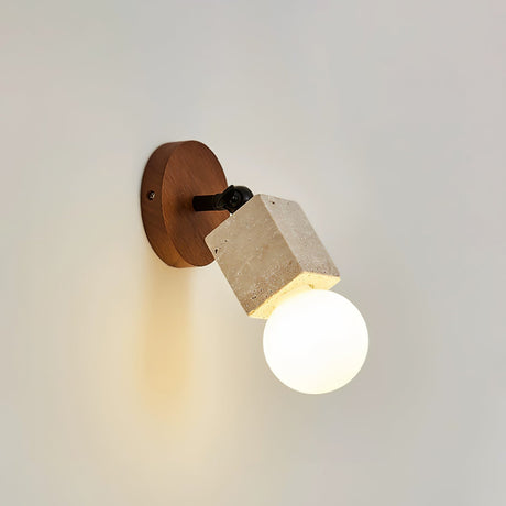 Open round bulb glowing at the end of a travertine tube on a wall