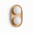 Light wood capsule with two opal globes set into its face, seen unlit