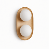 Light wood capsule with two opal globes set into its face, seen unlit