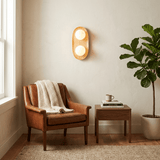 Sconce lit above a leather armchair with a throw, a side table and a plant