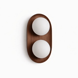 Walnut capsule with two opal globes set into its face, seen unlit