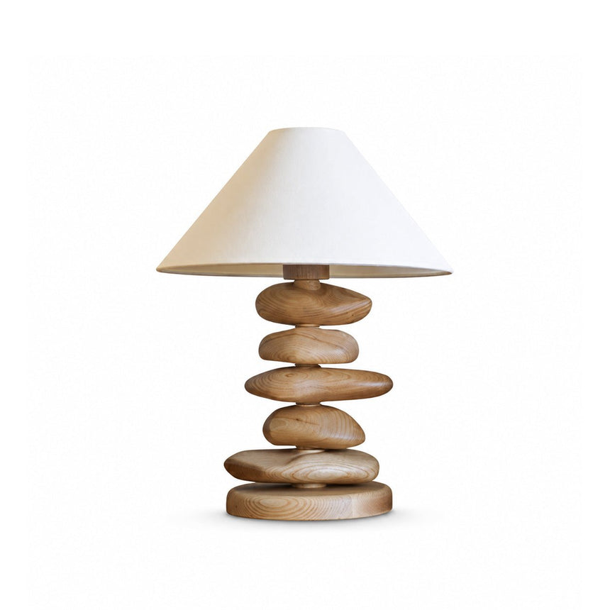 Unique table lamp with a light wood pebble stack on a plain ground