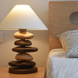 Unique table lamp with a mixed pebble stack lit and seen close