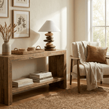 Unique table lamp on a console with books beside an armchair