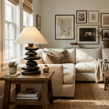 Unique table lamp lit on a console table beside a pale sofa