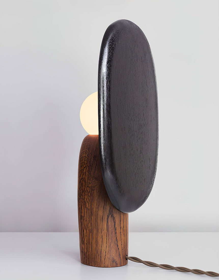 Charcoal backplate table lamp seen from an angle with the globe half hidden